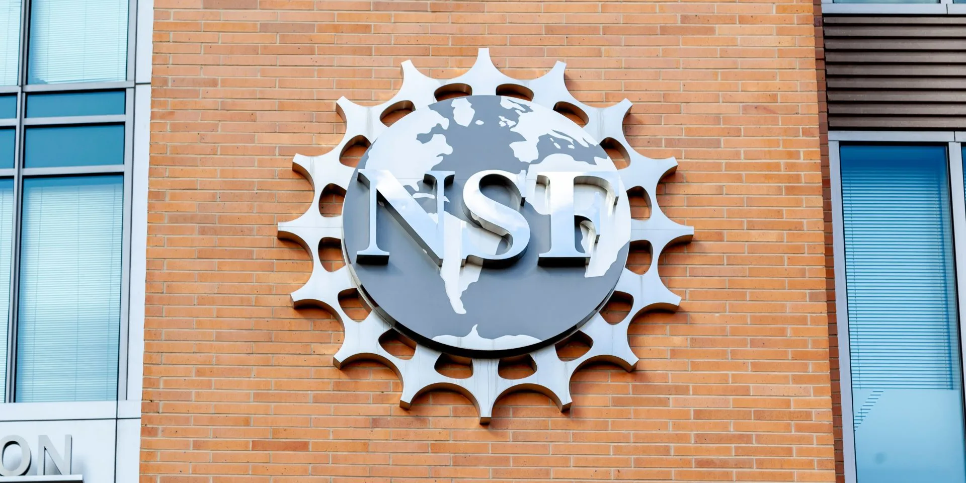 The logo for the National Science Foundation at the side of a brick building